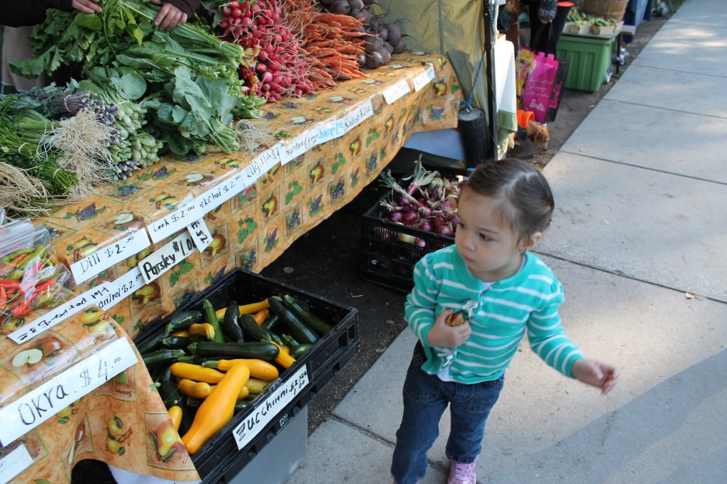 Lydia at the farmer's market. She appears intimidated by the produce.