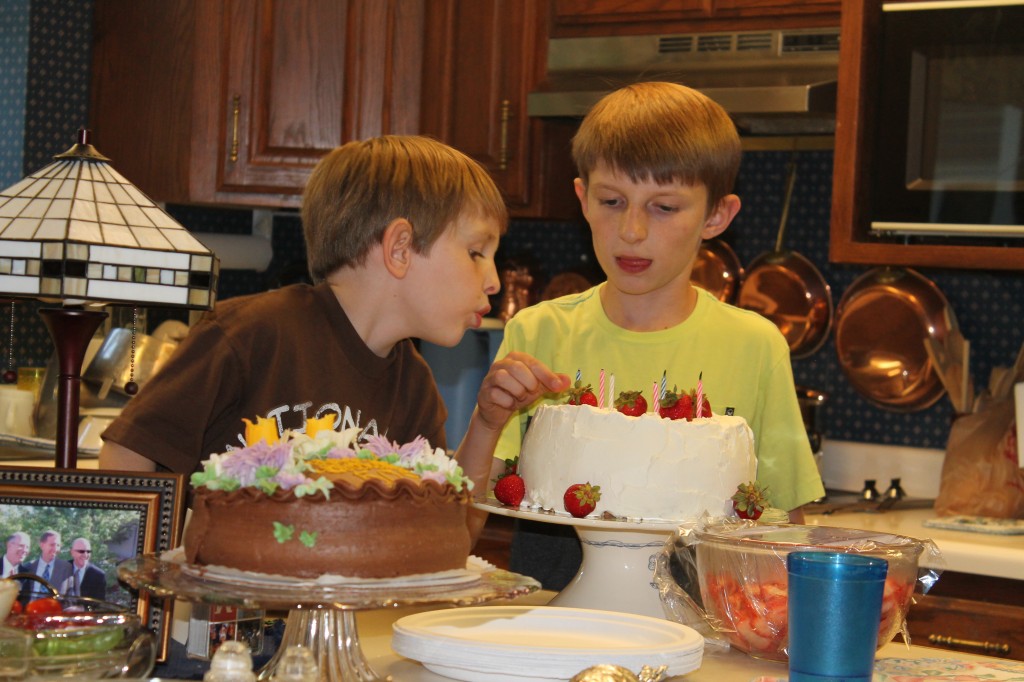 Charlie and Henry trying to blow out the trick candles once and for all.