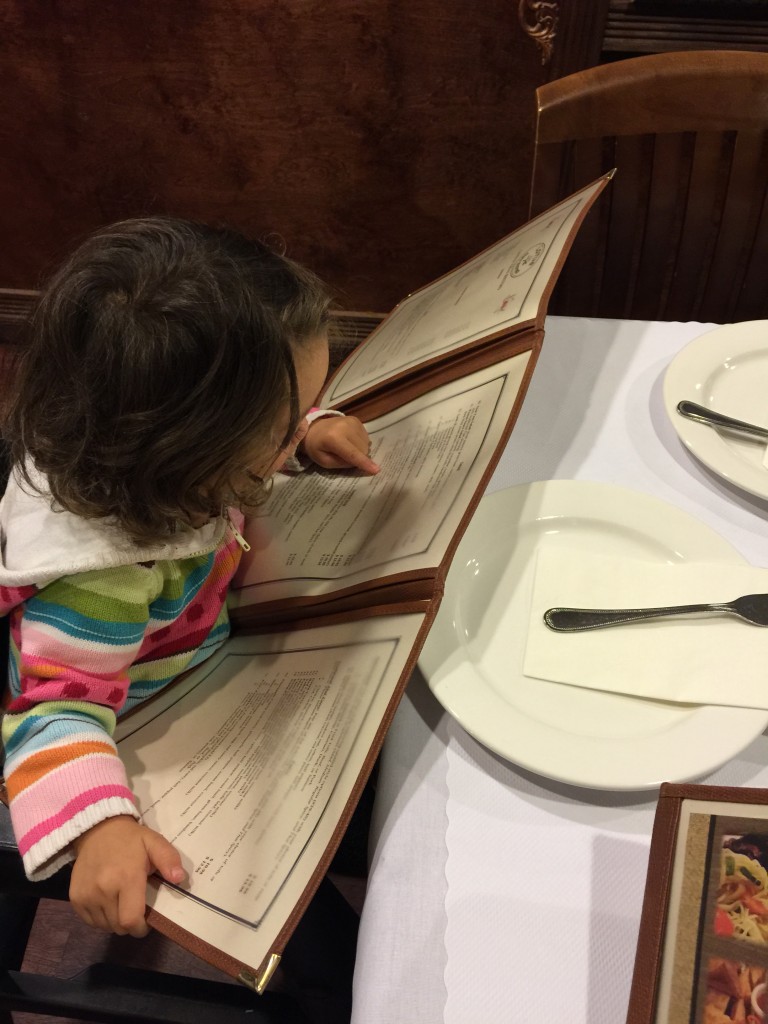 Mary "reading" the menu at dinner.