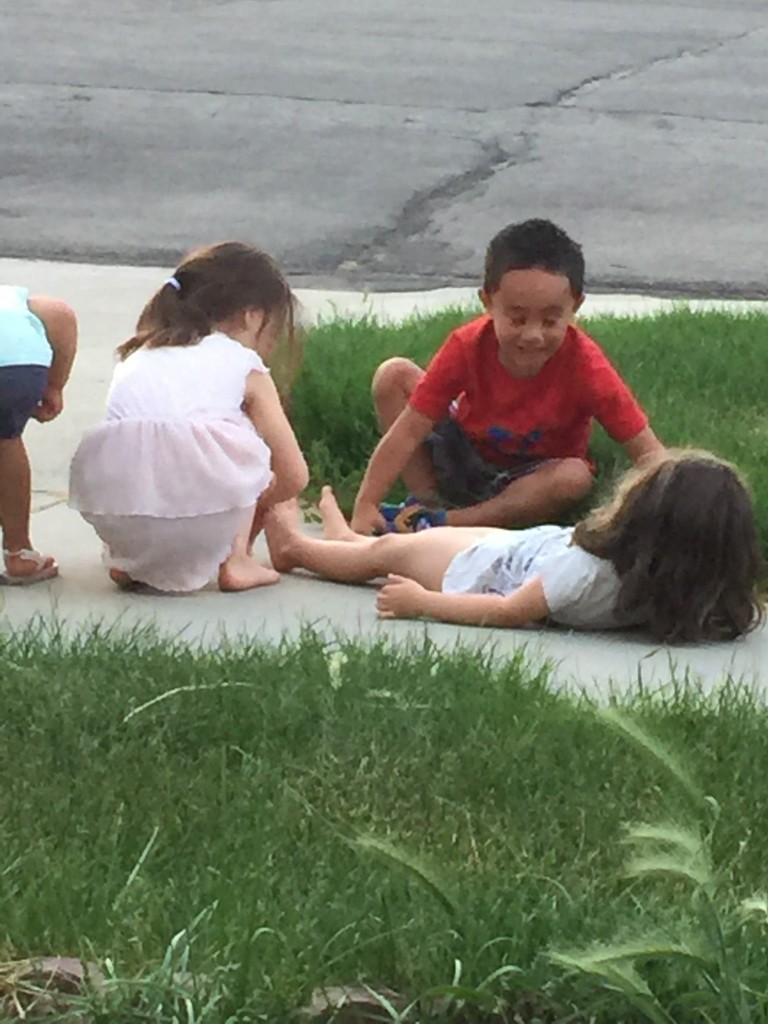 Neighborhood kids tracing Mary and each other with chalk. 