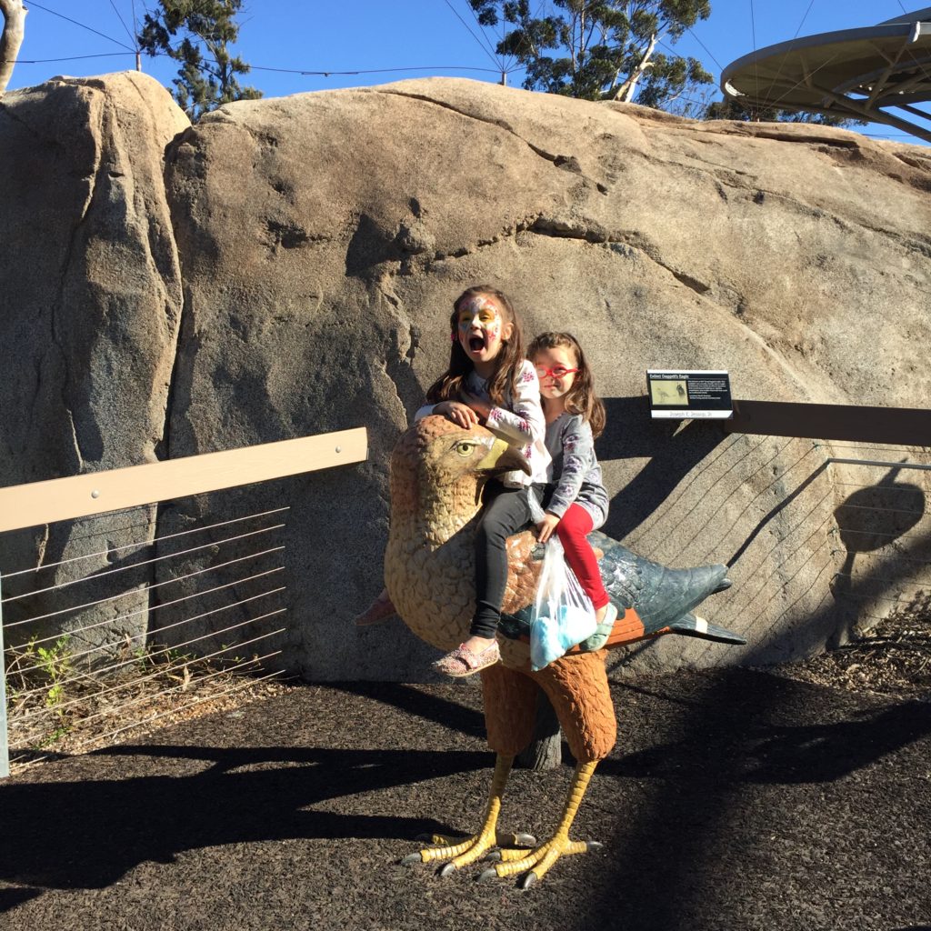 The girls are sitting on a LIFE SIZE replica of an extinct eagle.